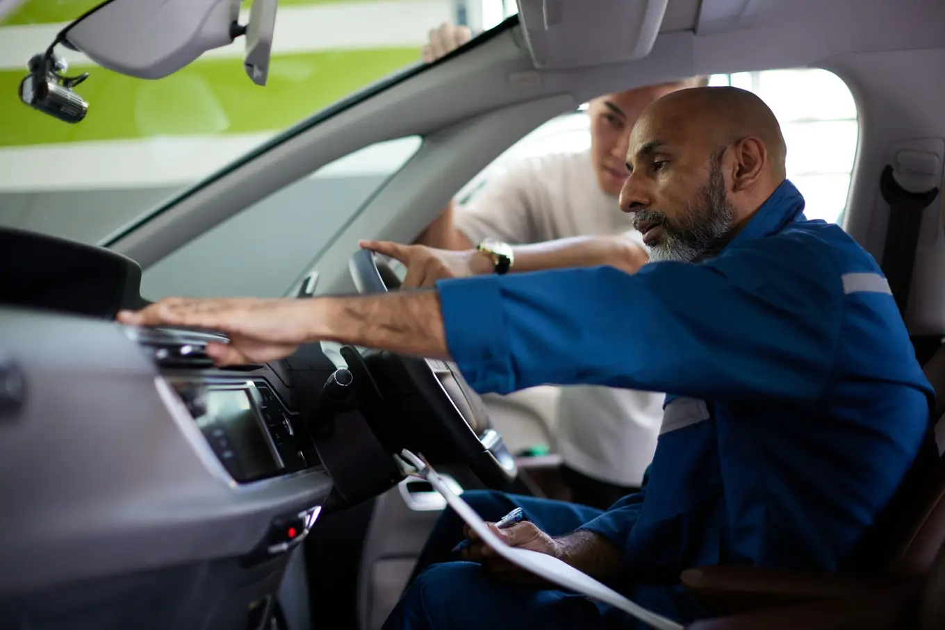 mechanik oglądający deskę rozdzielczą w samochodzie